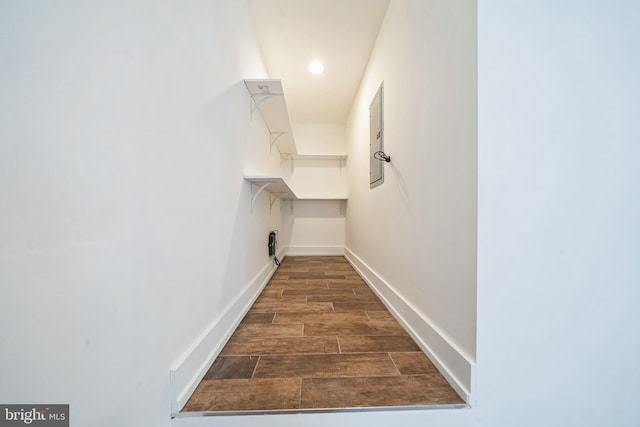 hallway featuring dark wood finished floors and baseboards