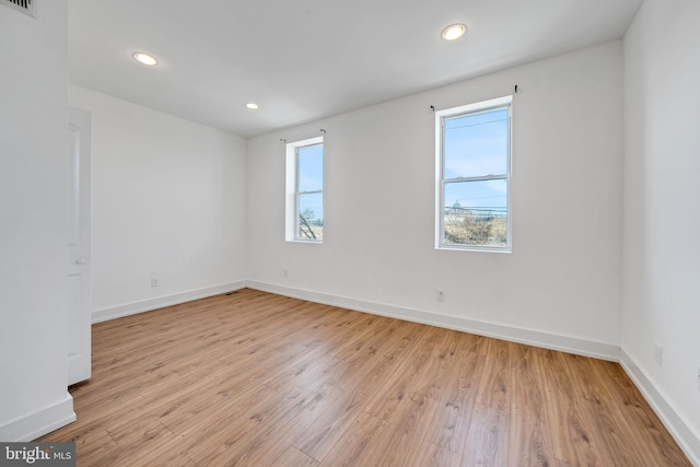 unfurnished room featuring recessed lighting, baseboards, visible vents, and light wood finished floors