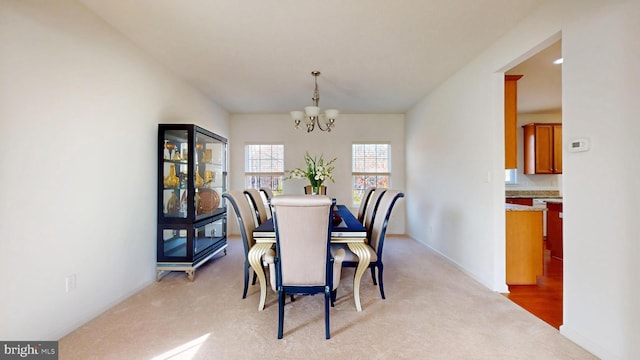 dining room featuring a chandelier and light carpet