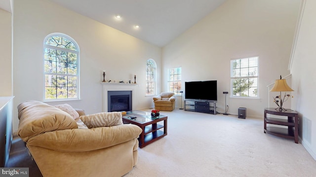 carpeted living room featuring high vaulted ceiling, a glass covered fireplace, baseboards, and recessed lighting