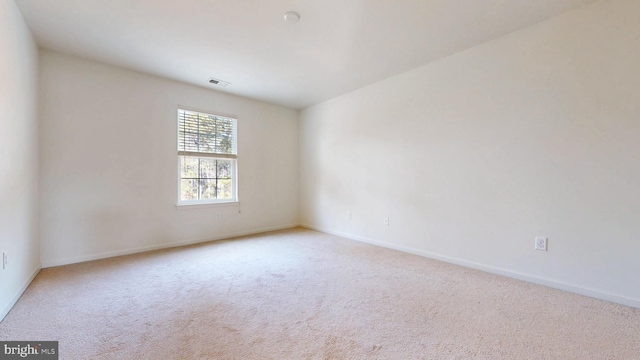 empty room with visible vents, baseboards, and light colored carpet