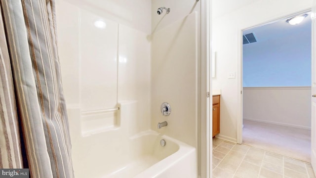 bathroom with bathing tub / shower combination, vanity, and baseboards