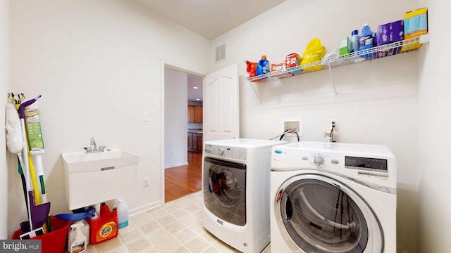 laundry area featuring laundry area, a sink, visible vents, baseboards, and washer and dryer