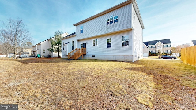 back of house featuring a yard, fence, and a residential view