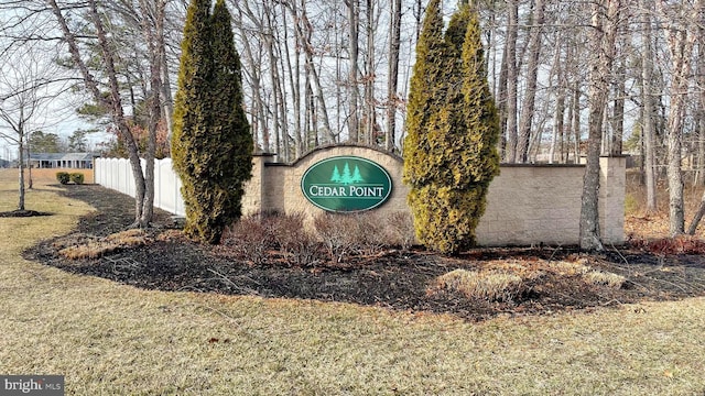 community sign featuring a yard and fence