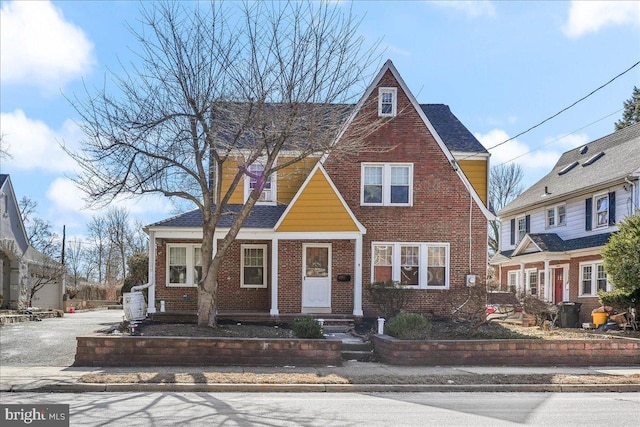 view of front facade featuring brick siding and a shingled roof