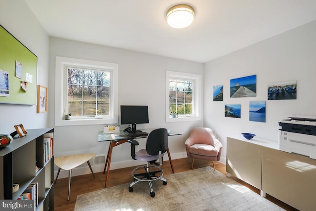 office space with visible vents, baseboards, and wood finished floors