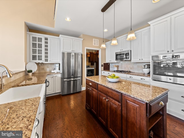 kitchen with dark wood-style flooring, visible vents, appliances with stainless steel finishes, and a sink
