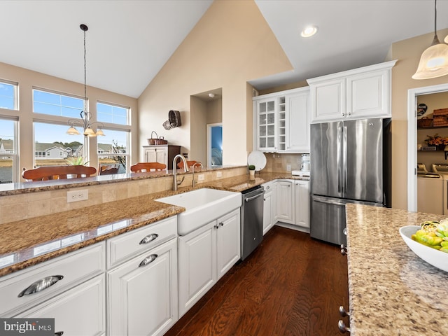 kitchen featuring a sink, white cabinets, washing machine and dryer, and stainless steel appliances
