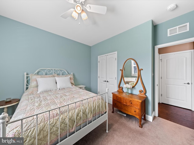 bedroom featuring visible vents, a closet, carpet flooring, baseboards, and ceiling fan