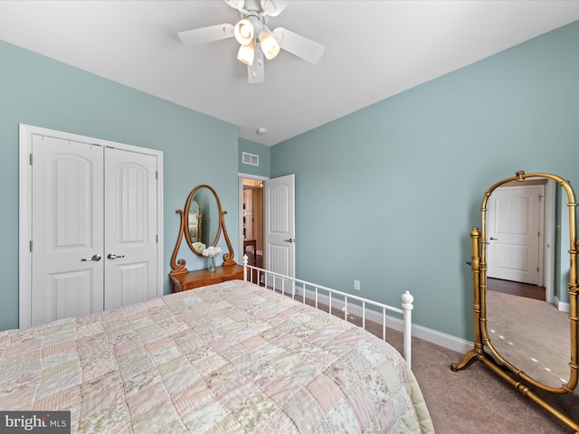 carpeted bedroom with a closet, baseboards, visible vents, and ceiling fan