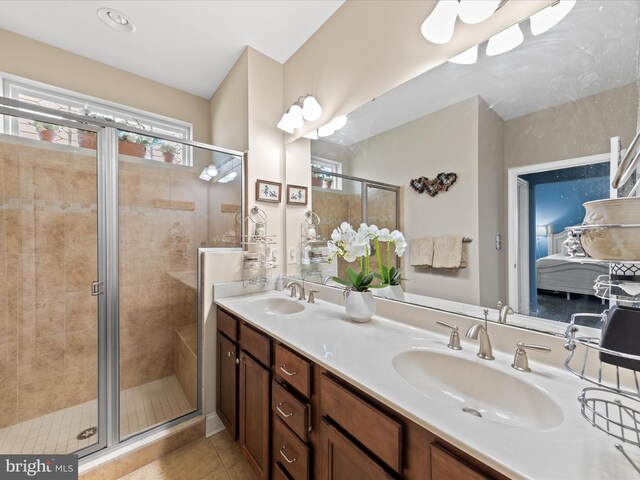 bathroom featuring tile patterned floors, a shower stall, and a sink