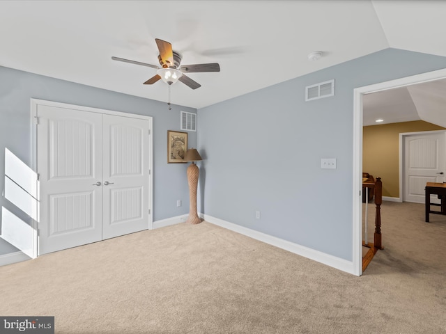 unfurnished bedroom with lofted ceiling, carpet, and visible vents