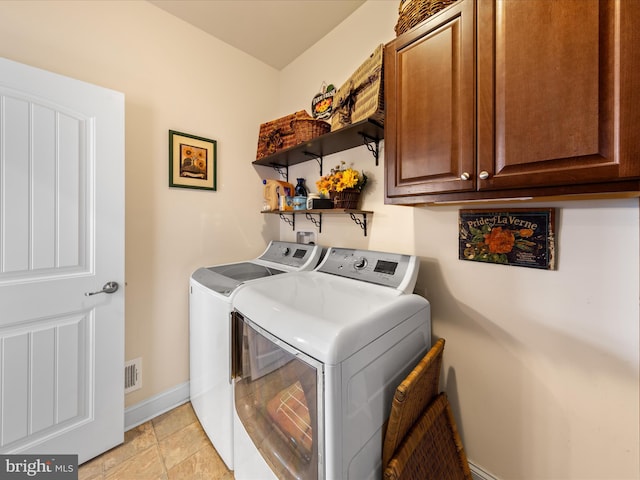 laundry room with washing machine and clothes dryer, visible vents, cabinet space, and baseboards