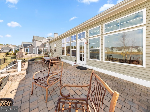 view of patio / terrace with a residential view, outdoor dining space, and fence
