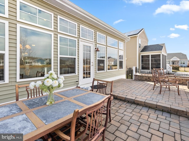 view of patio / terrace with outdoor dining space and a sunroom