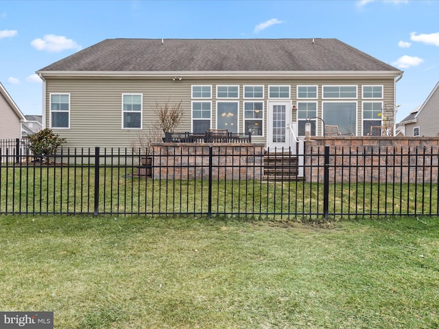 back of property featuring fence private yard, a lawn, and a shingled roof