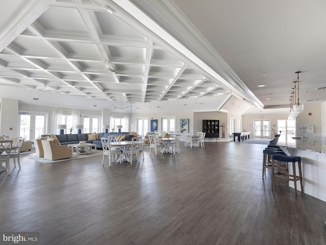 living area featuring beam ceiling, dark wood-type flooring, ornamental molding, and coffered ceiling