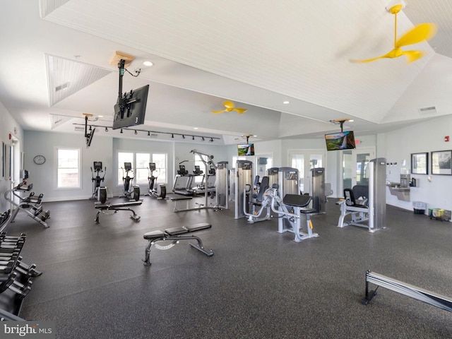 exercise room with visible vents, baseboards, and lofted ceiling