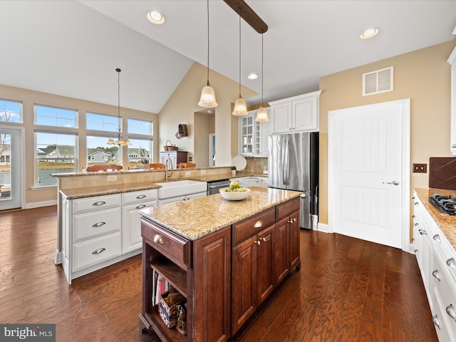 kitchen with a sink, visible vents, white cabinetry, and stainless steel appliances