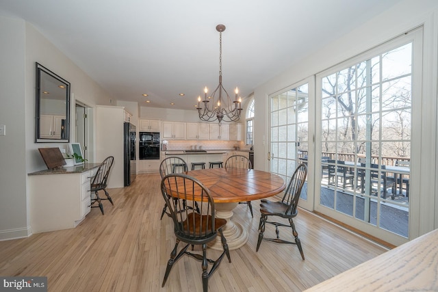 dining room with a notable chandelier and light wood finished floors