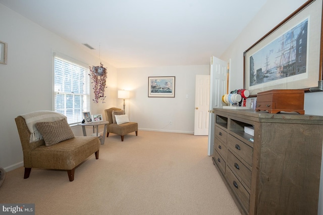 living area with light carpet, visible vents, and baseboards