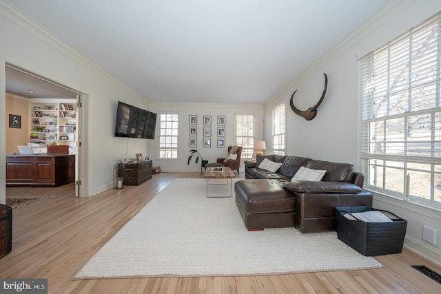 living room featuring baseboards, crown molding, visible vents, and wood finished floors