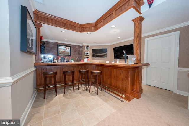 bar featuring recessed lighting, ornamental molding, wet bar, ornate columns, and tile patterned floors