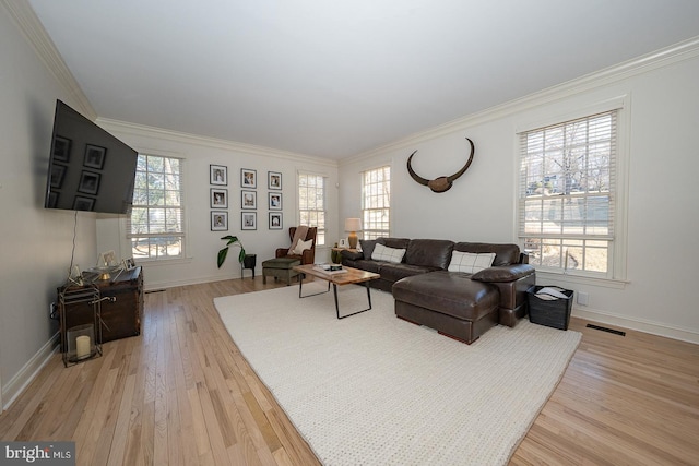 living area with a healthy amount of sunlight, light wood finished floors, visible vents, and crown molding