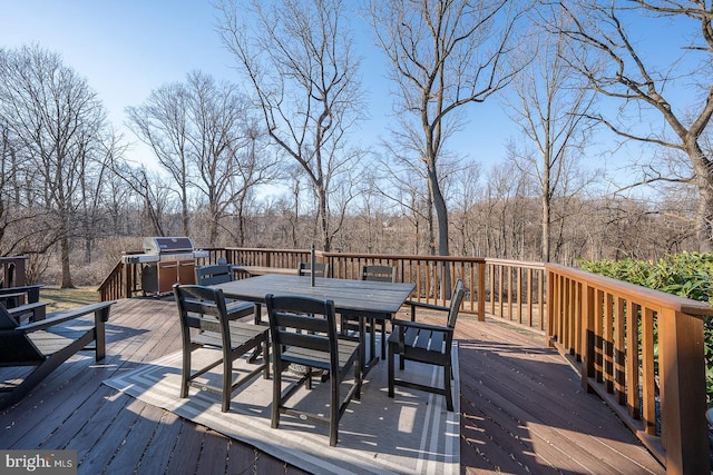 wooden deck featuring outdoor dining space and grilling area