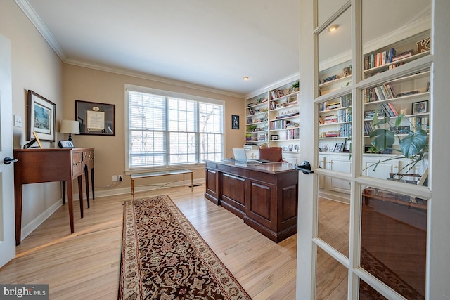 office area with baseboards, french doors, light wood-style flooring, and crown molding