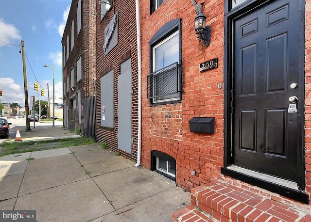 doorway to property with brick siding