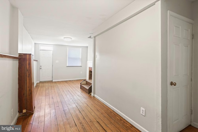 hallway with hardwood / wood-style flooring and baseboards