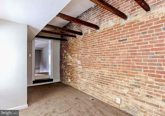 hall with brick wall, carpet flooring, beam ceiling, and baseboards