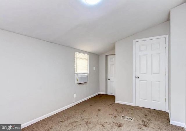 unfurnished bedroom featuring carpet flooring, vaulted ceiling, visible vents, and baseboards