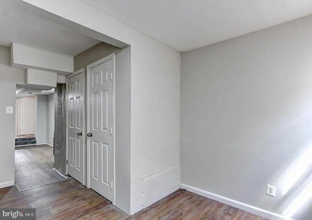 hall with dark wood-style floors and baseboards