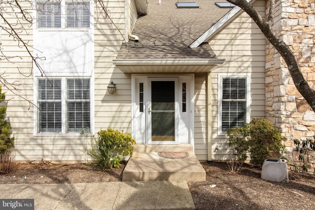 doorway to property with roof with shingles