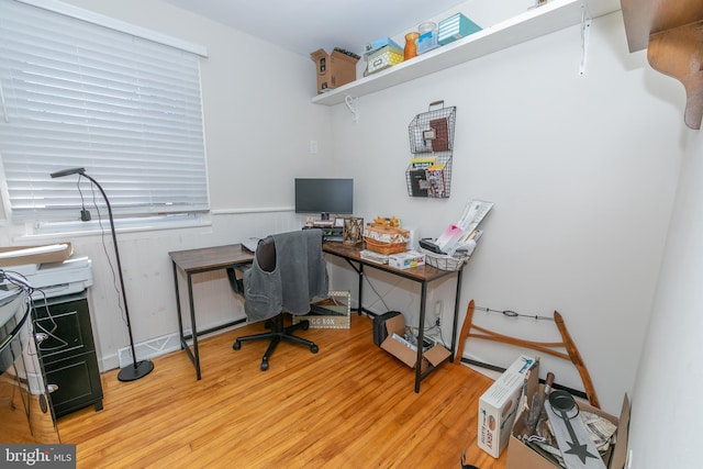 home office featuring a wainscoted wall and light wood finished floors