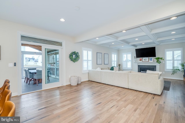 living area featuring a wealth of natural light, beamed ceiling, light wood finished floors, and recessed lighting