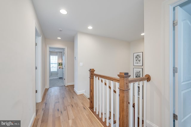 corridor with recessed lighting, baseboards, light wood finished floors, and an upstairs landing