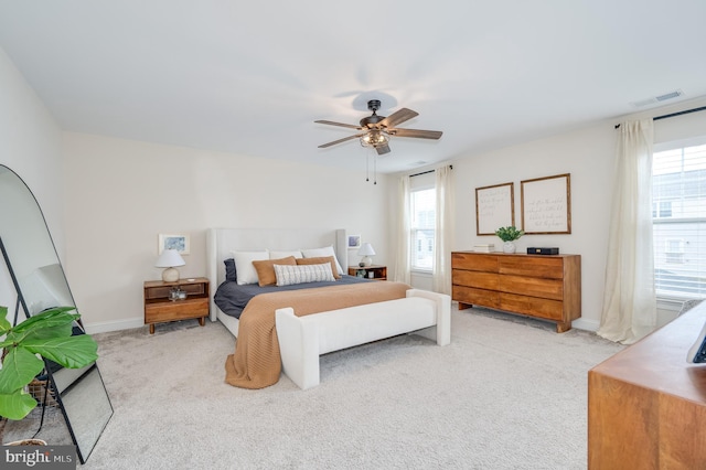 carpeted bedroom featuring baseboards, visible vents, and a ceiling fan