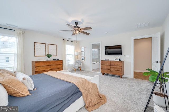 bedroom featuring baseboards, ceiling fan, visible vents, and light colored carpet