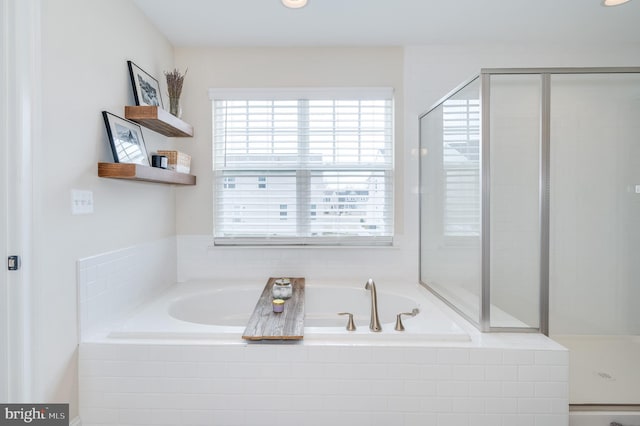 bathroom featuring a shower stall and a bath