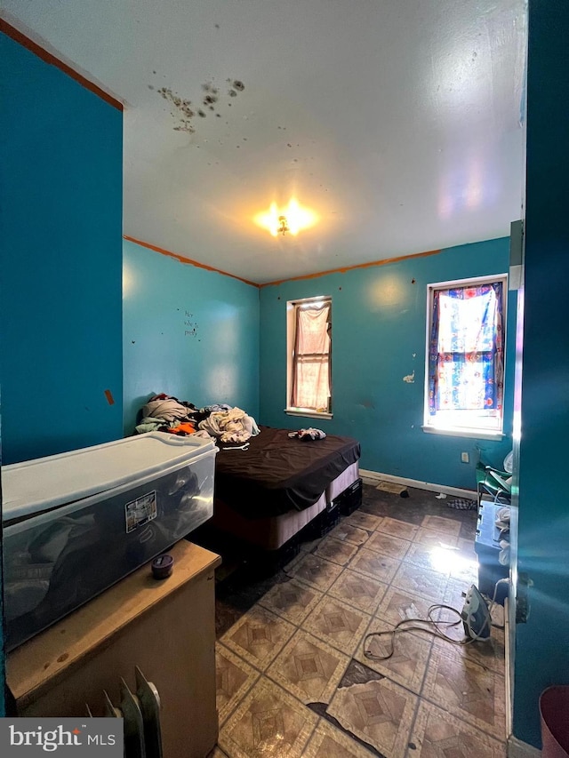 bedroom with baseboards and tile patterned floors