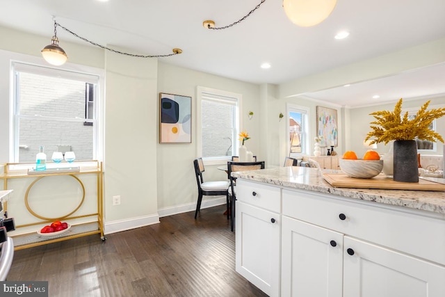 kitchen with dark wood-style flooring, recessed lighting, white cabinets, light stone countertops, and baseboards