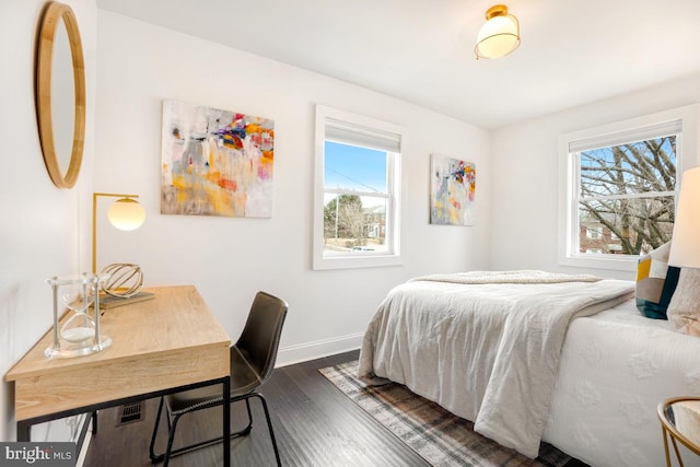 bedroom with dark wood-style flooring, multiple windows, and baseboards