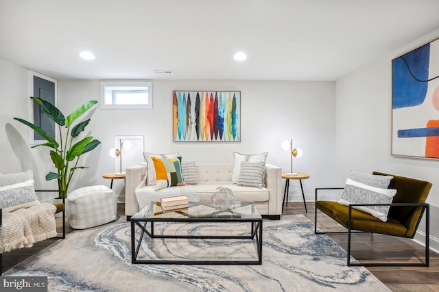 living area with recessed lighting, wood finished floors, visible vents, and baseboards