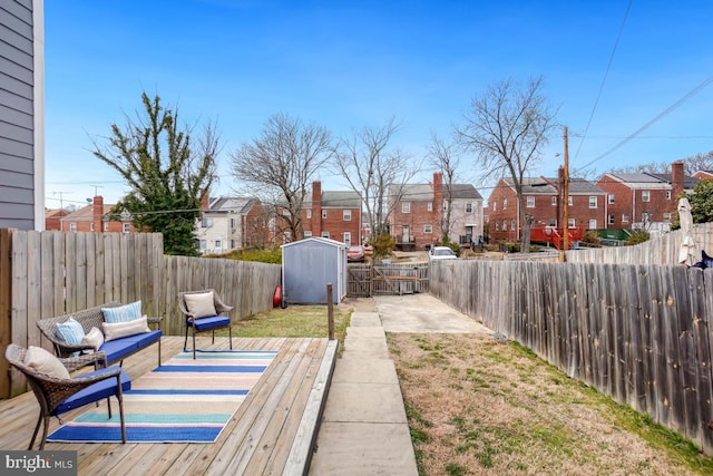 view of yard with a storage shed, an outdoor structure, a fenced backyard, and a residential view