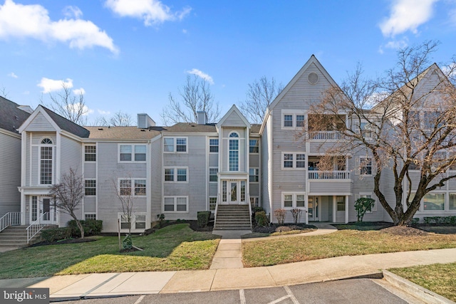 multi unit property with french doors, uncovered parking, and a front yard