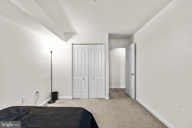 bedroom with a closet, baseboards, and carpet floors